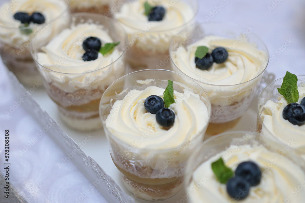 Serving a sweet table with a creamy dessert with a fruit accent Serving a sweet table with a creamy dessert with a fruit accent