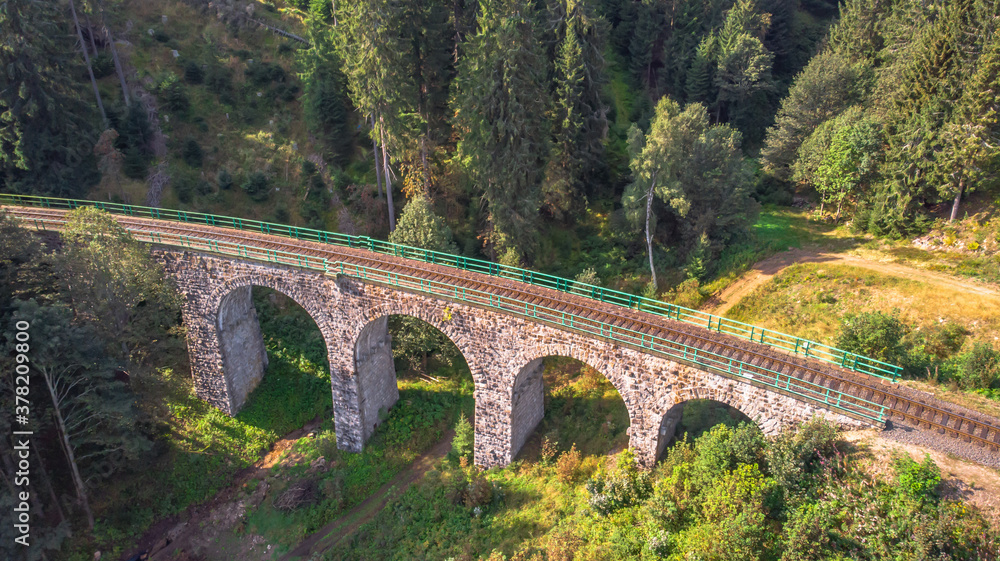 Aerial top view of stone Railway Viaduct in a small village of Pernink, Czech republic. Old Czech railway line. Vintage arch bridge.