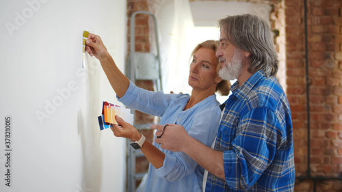 фотографія Senior couple with color swatch choosing painting for new home
