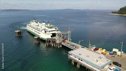 Drone / aerial footage of the  Washington State ferry and the ferry terminal with cars loading and unloading in Fountleroy, near Lincoln Park and Seattle, in King County Washington photo