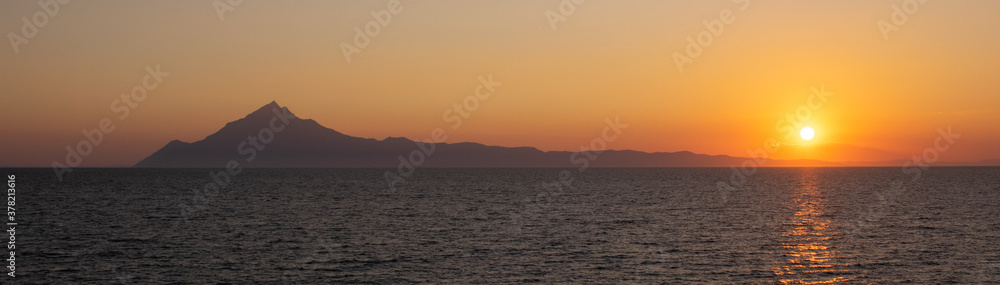 Panorami view of Athos mountain in Greece seen from the Mediterranean Sea at sunset