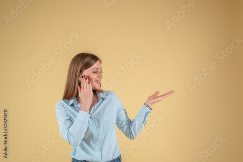 Woman showing your product isolated on yellow background, empry space photo