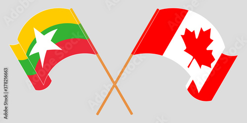 Crossed and waving flags of Myanmar and Canada
