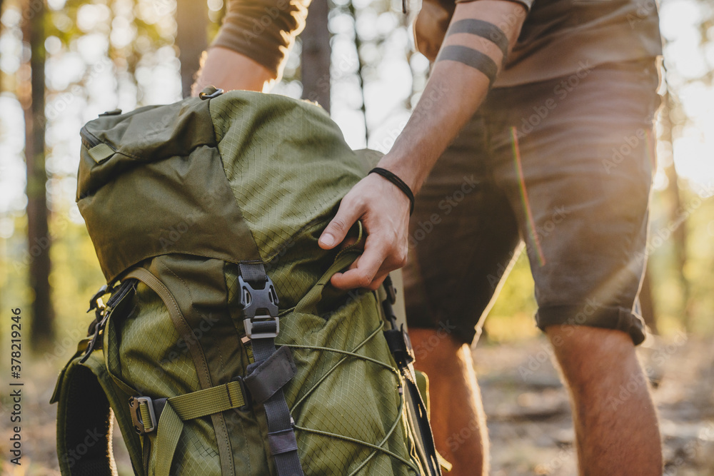 © InsideCreativeHouse - Close up of male hiker holding his camping backpack. Traveler opening backpack while traveling in beautiful wood © InsideCreativeHouse - Close up of male hiker holding his camping backpack. Traveler opening backpack while traveling in beautiful wood