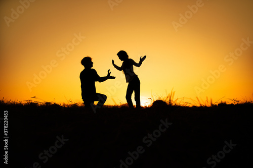 Silhouettes of couple man and woman In Nature sunset. Couple love concept.
