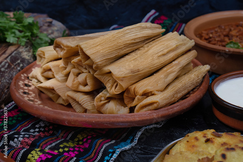 Foto Vegan tamales filled with seitan, masa, chile verde and served with ranchero sau