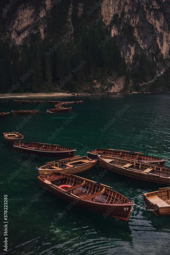 romantic place with brown wooden boats stand on the azure water on the alpine lake Lago di Braies. Dolomites, South Tyrol, Italy, Europe. italian alps.