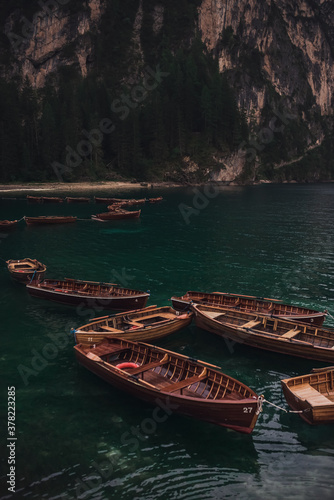 romantic place with brown wooden boats stand on the azure water on the alpine lake Lago di Braies. Dolomites, South Tyrol, Italy, Europe. italian alps.