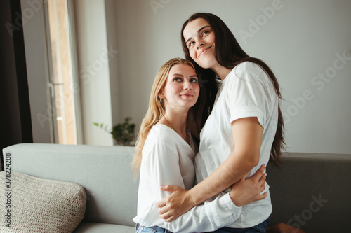 Happy girlfriends in love hugging indoors