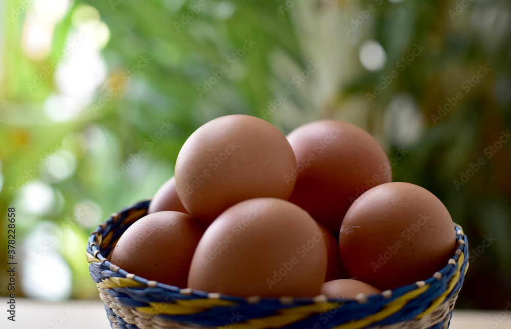 Brown eggs in a wicker basket on a rustic wooden plankEaster eggs In Paper Container, selective focus points. Brown eggs in a wicker basket on a rustic wooden plankEaster eggs In Paper Container, selective focus points.