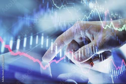 Multi exposure of man's hands holding and using a digital phone and forex graph drawing. Financial market concept.