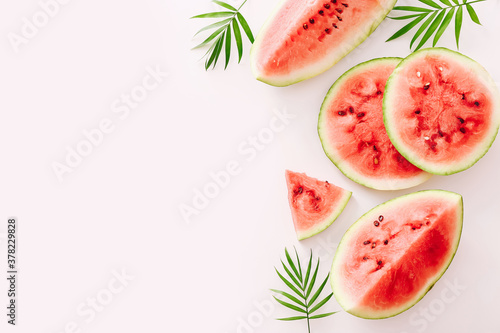 Sliced watermelon on a white background with a green leaves. Copy space