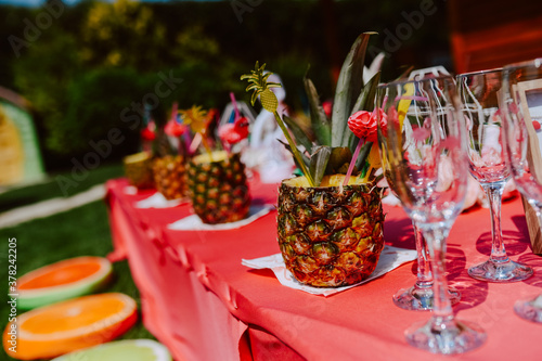 Decorated table with pineapple cocktails to celebrate a bachelorette party in a beautiful garden. The girls are having a party
