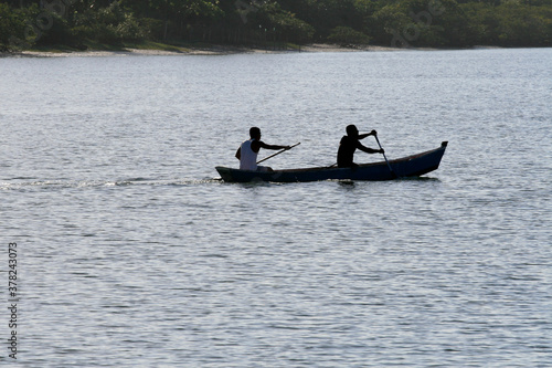 caravelas, bahia / brazil - september 11, 2008: people are seen in a rowboat in the waters of the Caravalas river in the city of Caravelas in southern Bahia. photo