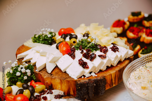 Various types of cheese served on a board at the event. Meze for party guests