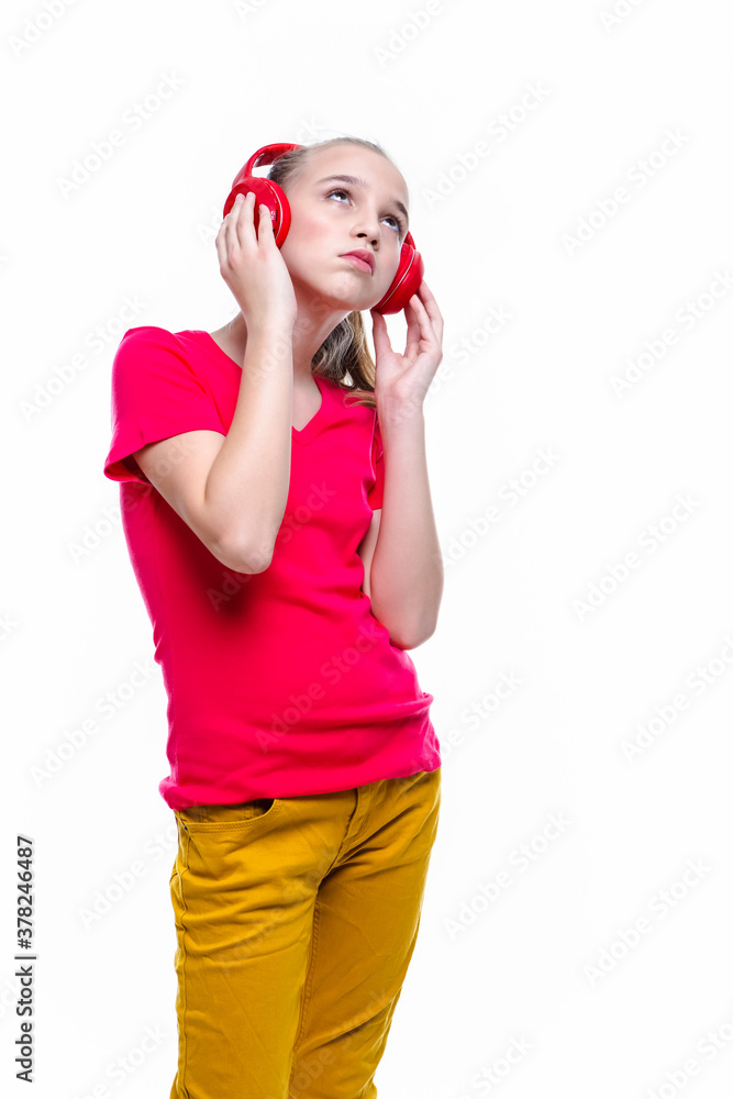 Portrait of Positive Caucasian Teenager Girl With Red Headphones Enjoying Music. Posing Against White. Portrait of Positive Caucasian Teenager Girl With Red Headphones Enjoying Music. Posing Against White.