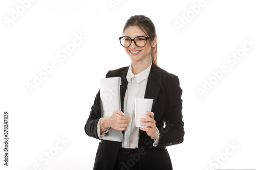 woman holding laptop and cup of coffee ready for work smiling