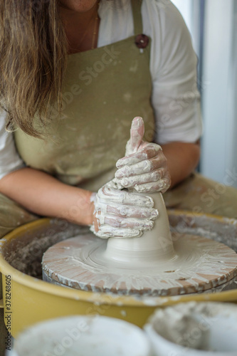 Woman making pottery on the wheel