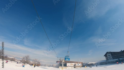 Winter sunset ski resort Bansko with ski slope, gondola lift cabins photo