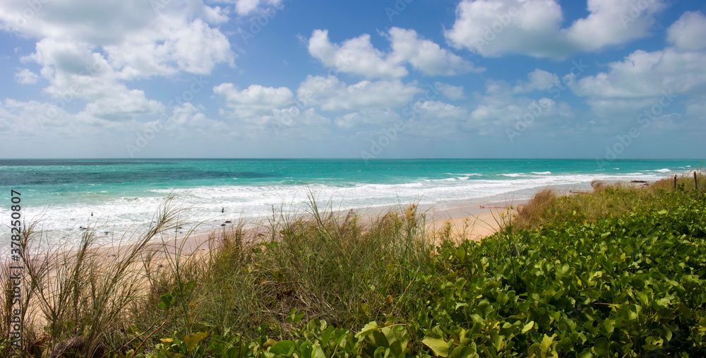 Waves rolling in as the tide ebbs out on a late morning in the Indian Ocean at Cable Beach, Broome ,North Western Australia in the Summer Wet Season create a delightful tropical seascape.