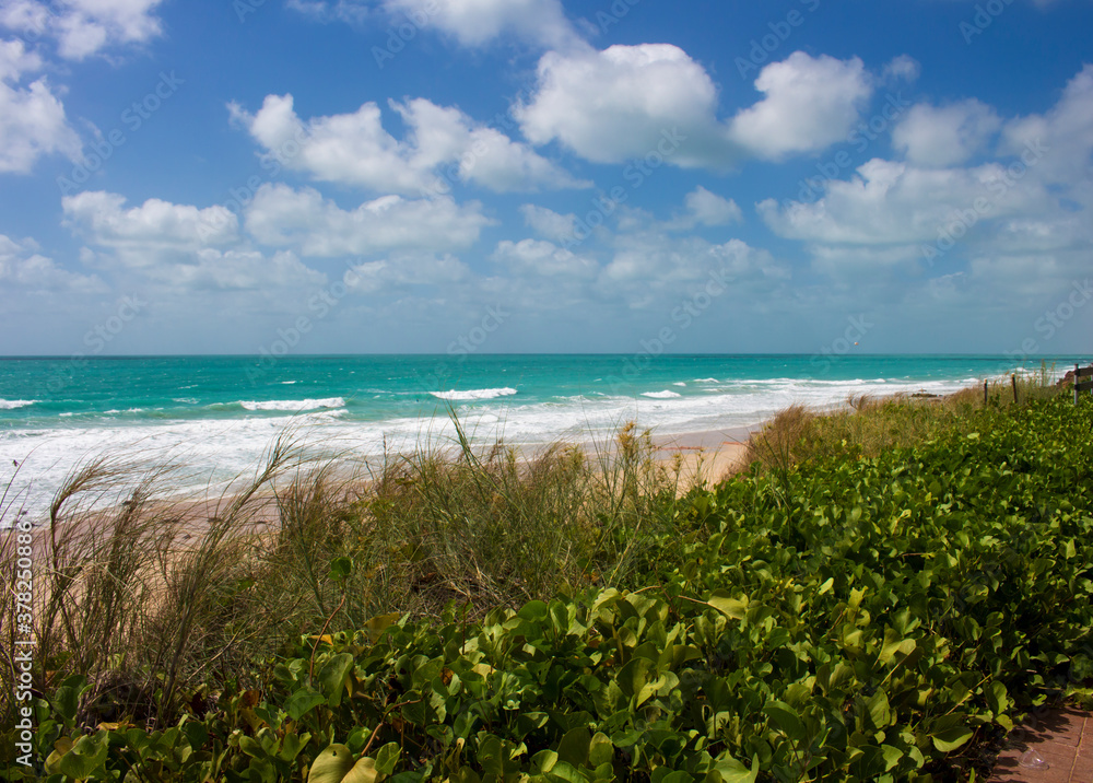 Waves rolling in as the tide ebbs out on a late morning in the Indian Ocean at Cable Beach, Broome ,North Western Australia in the Summer Wet Season create a delightful tropical seascape.