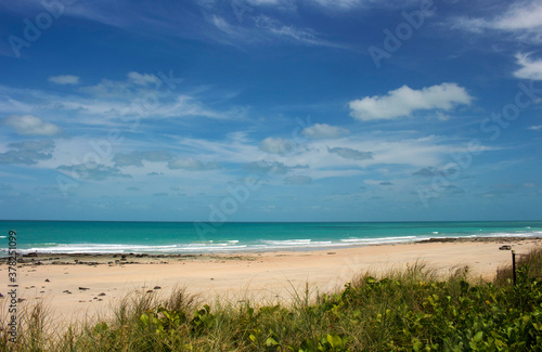 Waves rolling in as the tide ebbs out on a late morning in the Indian Ocean at Cable Beach  Broome  North Western Australia in the Summer Wet Season create a delightful tropical seascape.