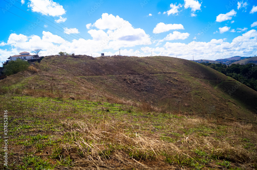 landscape mountain with lower green grass and clouds in a blue sky landscape mountain with lower green grass and clouds in a blue sky