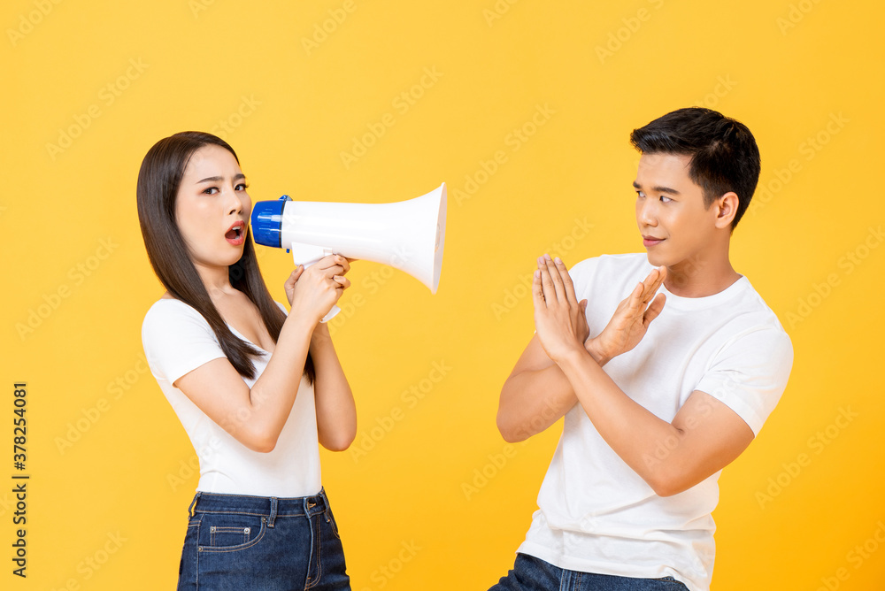 Portrait of Asian couple reacting to negative announcement in isolated studio yellow backgound