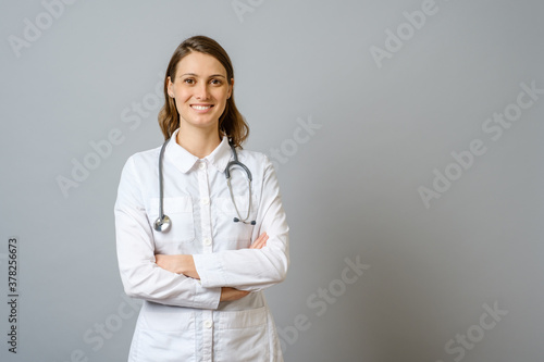 Smiling female doctor in lab coat with arms crossed