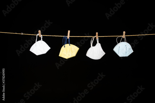 Canvas Print Masks are hanging from rope on isolated black background