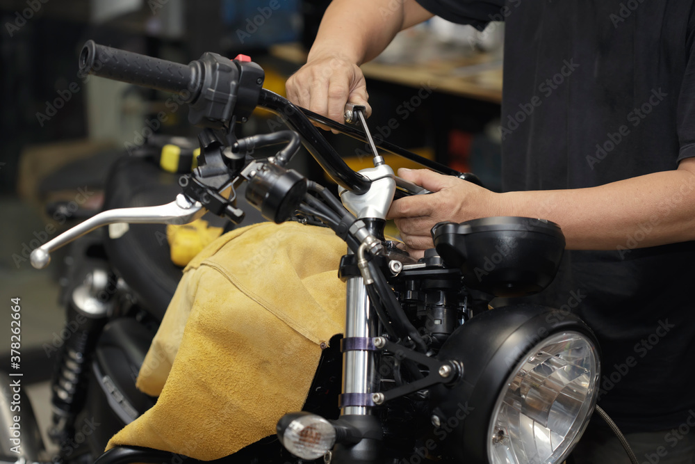 Φωτογραφία mechanic using Hex Key Wrench working on motorcycle at motorbike garage , concept of motorcycle maintenance and repair