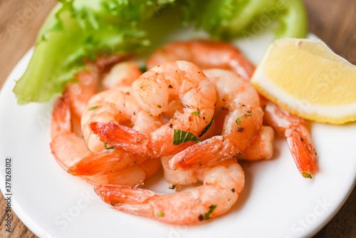 Appetizing cooked shrimps baked prawns , Seafood shelfish - Shrimp grilled delicious seasoning spices on white plate wooden background