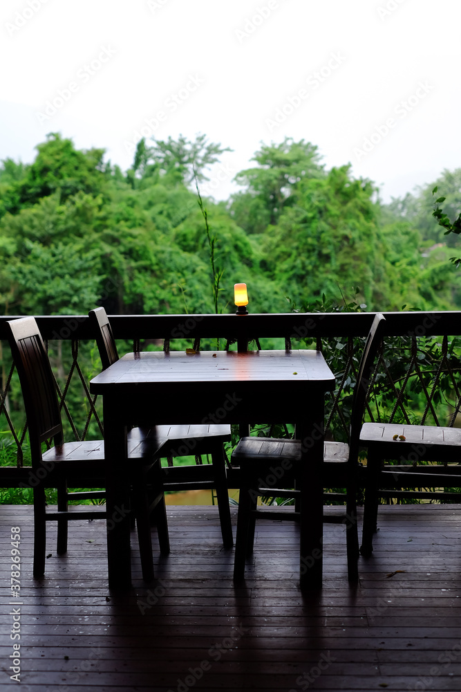 wood table and chairs restaurant riverside on forest and mountain nature background