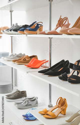 Shelves with stylish shoes in modern store