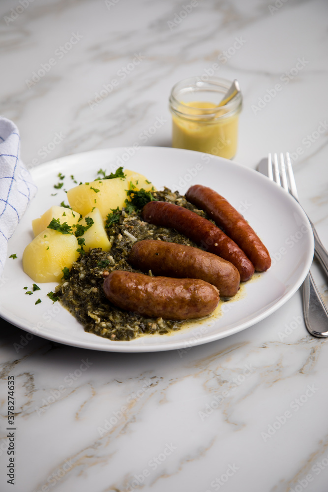 Oldenburger Grünkohl mit Pinkel, Kohlwurst, Senf und Kartoffeln auf Marmor Tisch Oldenburger Grünkohl mit Pinkel, Kohlwurst, Senf und Kartoffeln auf Marmor Tisch