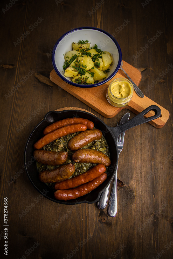 Oldenburger Grünkohl mit Pinkel, Kohlwurst, Senf und Kartoffeln in  Gusseisen Pfanne auf Holz Tisch Stock Photo | Adobe Stock