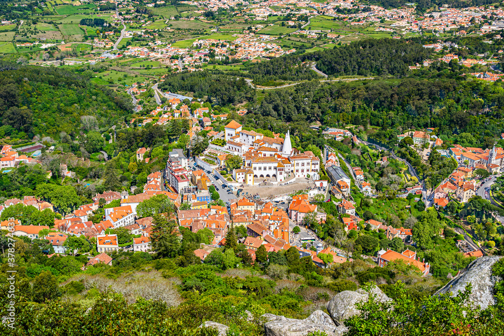 Scenic aerial view of the center of the touristic old town with houses and towers surrounded by green trees in Sintra, Portugal