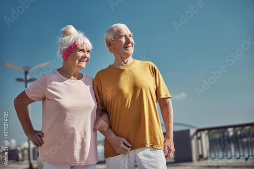 Εκτύπωση καμβά Two smiling pleased aged people standing outside