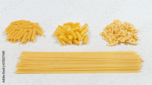 Various pasta on a fabric background. Assorted raw pasta. Gluten free food.