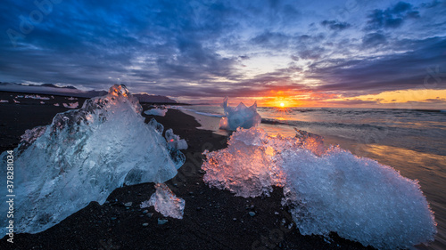 Glacial iceberg on black sand beach at Sunrise, Iceland photo