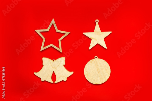 Christmas wooden decorations in the form of stars  bells and ball  on a red background