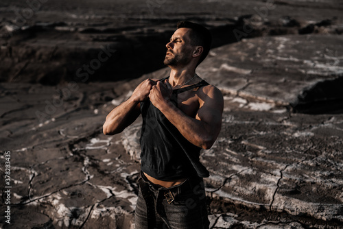 Attractive tanned man on the black sand