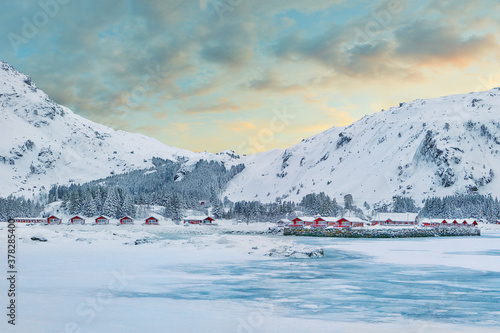 Stunning winter scenery with traditional Norwegian red wooden houses on the shore of Rolvsfjord on Vestvagoy island at Lofotens.