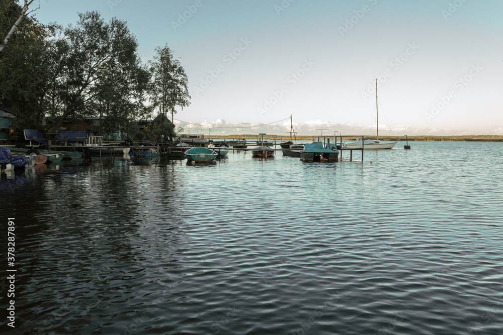 Fishing village with boats by the pier in Russia.