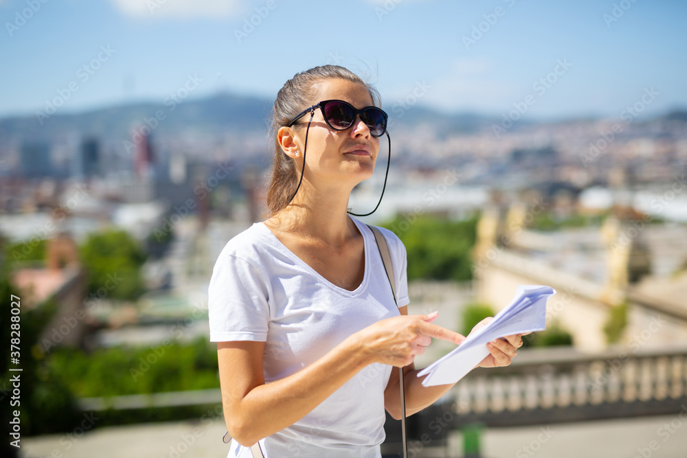 Portrait of young adult woman exploring outdoors exposition using paper guide