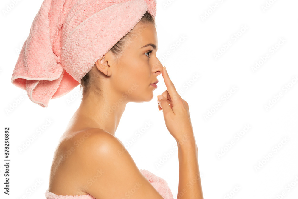 Young woman touching her nose, isolated on white background. Young woman touching her nose, isolated on white background.