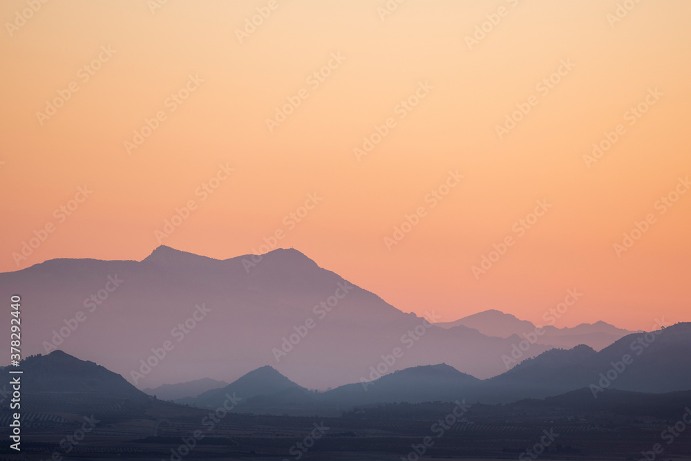 landscape of a sunrise with mountains and fields