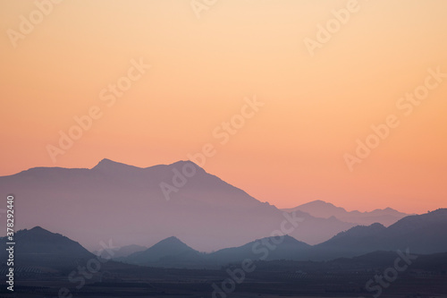 landscape of a sunrise with mountains and fields