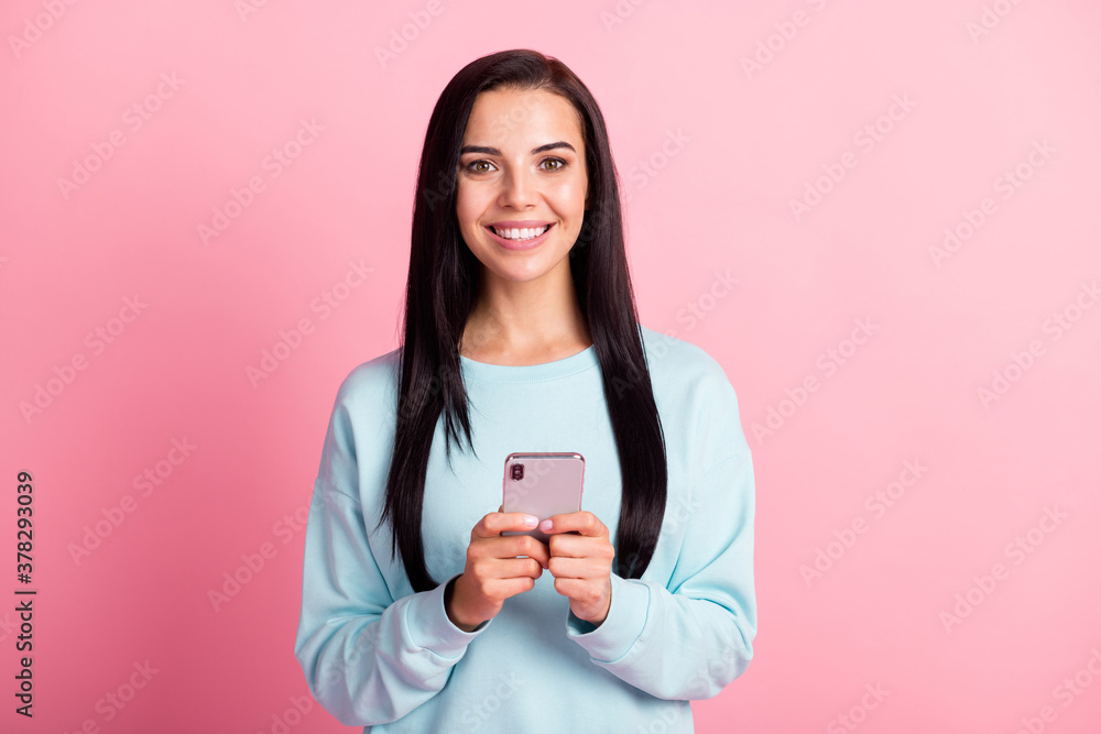 Photo of attractive cheerful lady hold telephone device hands wear sweatshirt pullover isolated pink color background Photo of attractive cheerful lady hold telephone device hands wear sweatshirt pullover isolated pink color background