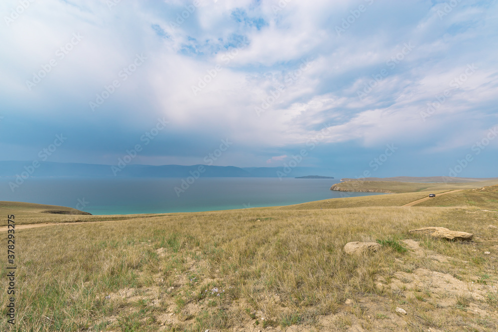 Picturesque sky over the Maloye More Strait. Federal highway on the steppe coast of Olkhon Island. Picturesque sky over the Maloye More Strait. Federal highway on the steppe coast of Olkhon Island.